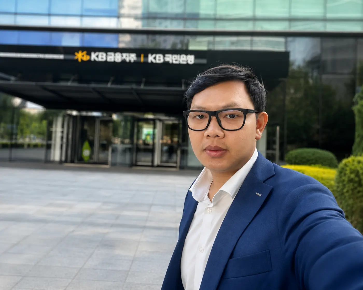 Phirum Seng standing outside a modern bank office building